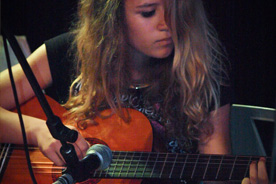 Girl playing accoustic guitar.