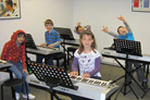 Junior keyboard lesson in clean, bright studio.