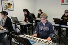 Keyboard lesson in clean, bright studio.
